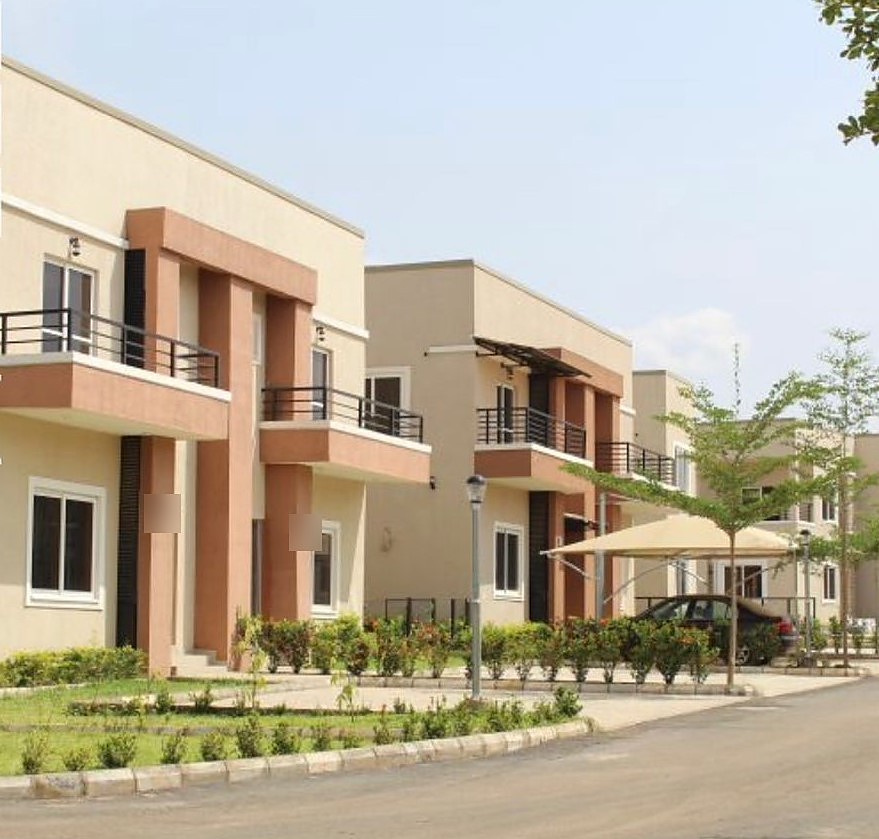 Two storey semi-detached homes on a landscaped estate road in Lokogoma, Abuja