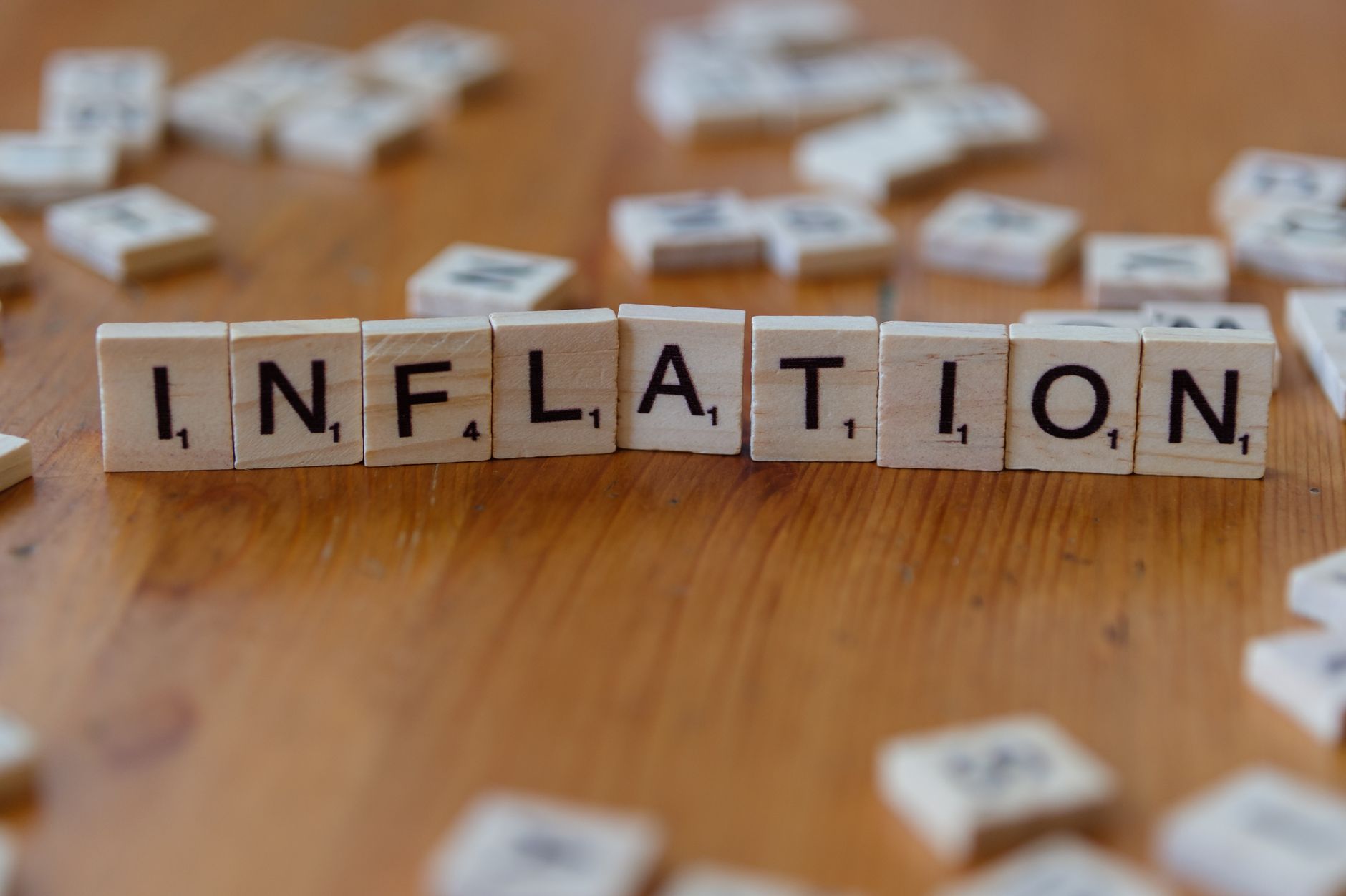 Lettered tiles spelling the word inflation on a wooden table