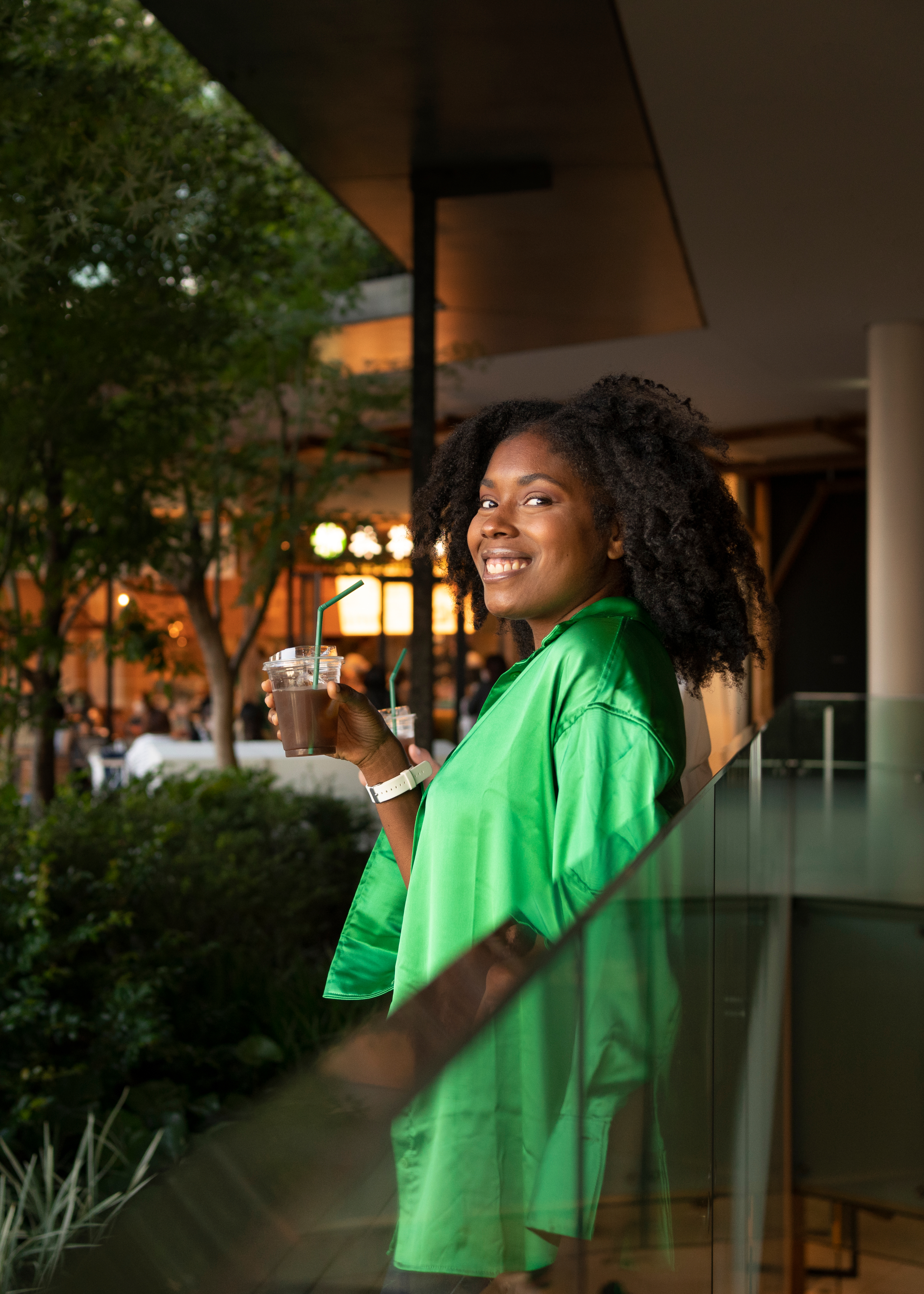 A resident smiling on a landscaped terrace outside a managed building