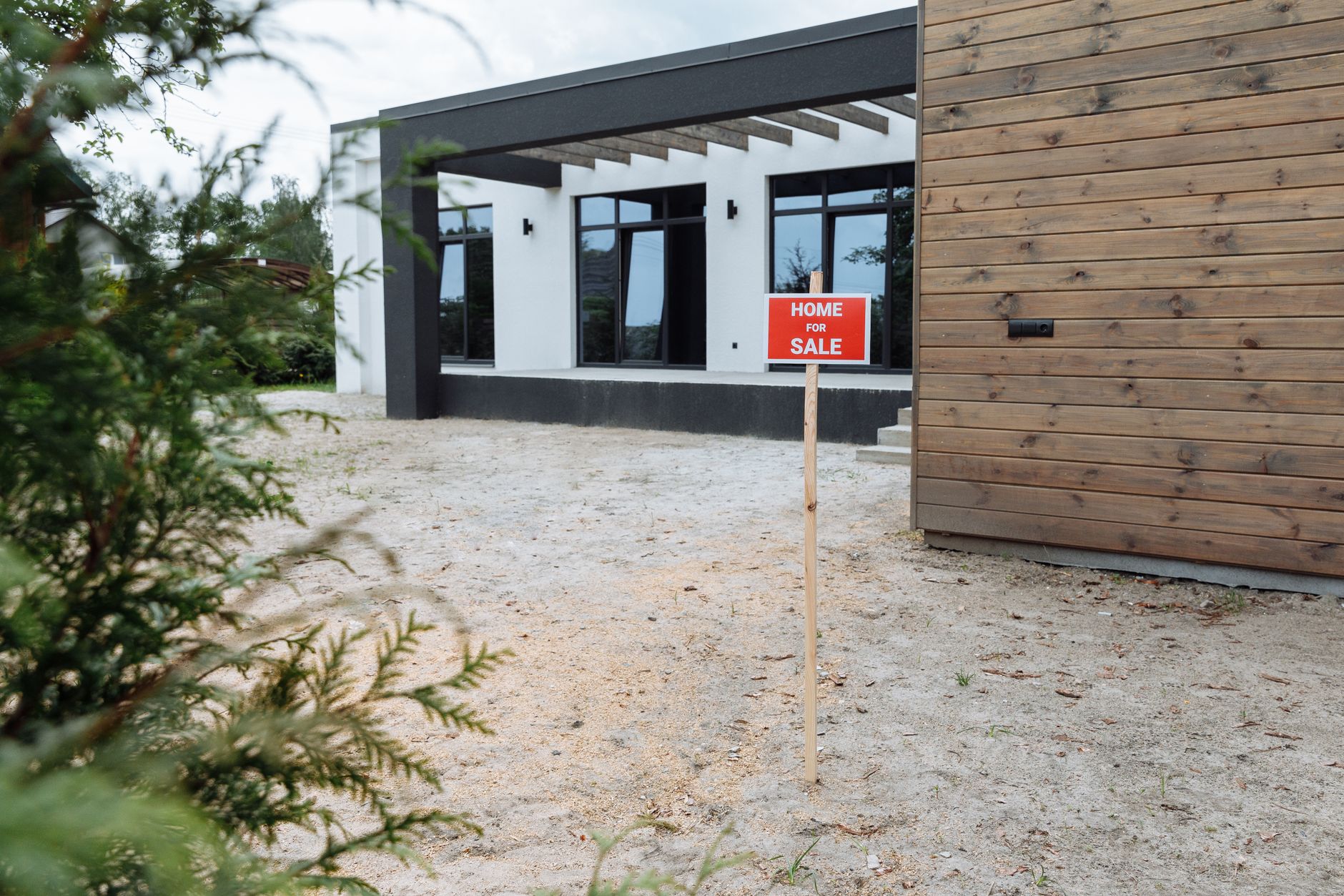 A newly built home with a for sale sign in the front yard
